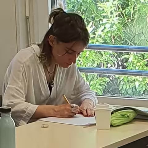 Une jeune ecrivaine fait courir son stylo dans un atelier d’ecriture Alchimie du Verbe.