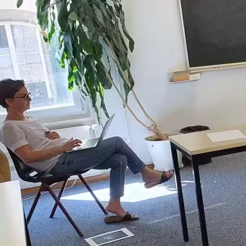 Une ecrivaine dans une position relax tape sur son clavier lors d’un atelier d’ecriture Alchimie du Verbe.